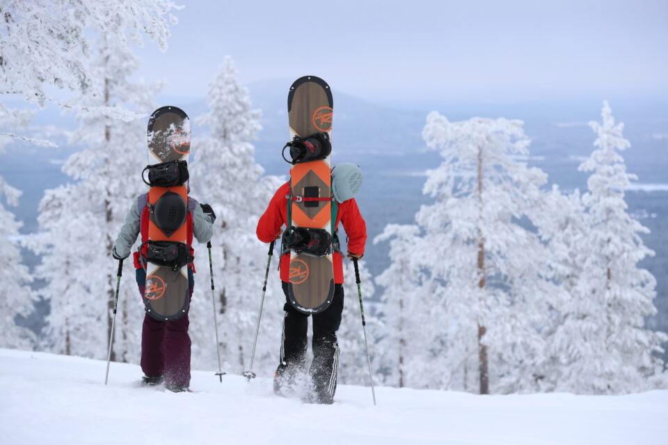 Snowboarders hiking in Suomu.